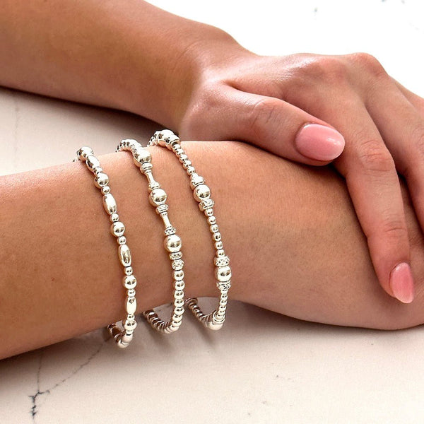 A close-up wrist shot of a lady's wrist, wearing the sterling silver All About The Beads 2 beaded bracelet stack.