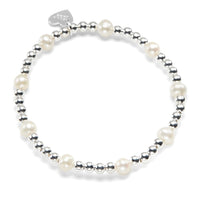 Pearl and silver beaded bracelet on a white background