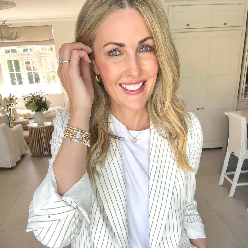 Becks (@thehousebuild) in a white pinstripe blazer in a bright, modern kitchen, wearing Bella Jane bracelets