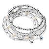 Stack of silver beaded bracelets with pearls, heart charm, birthstone charm, on a white background