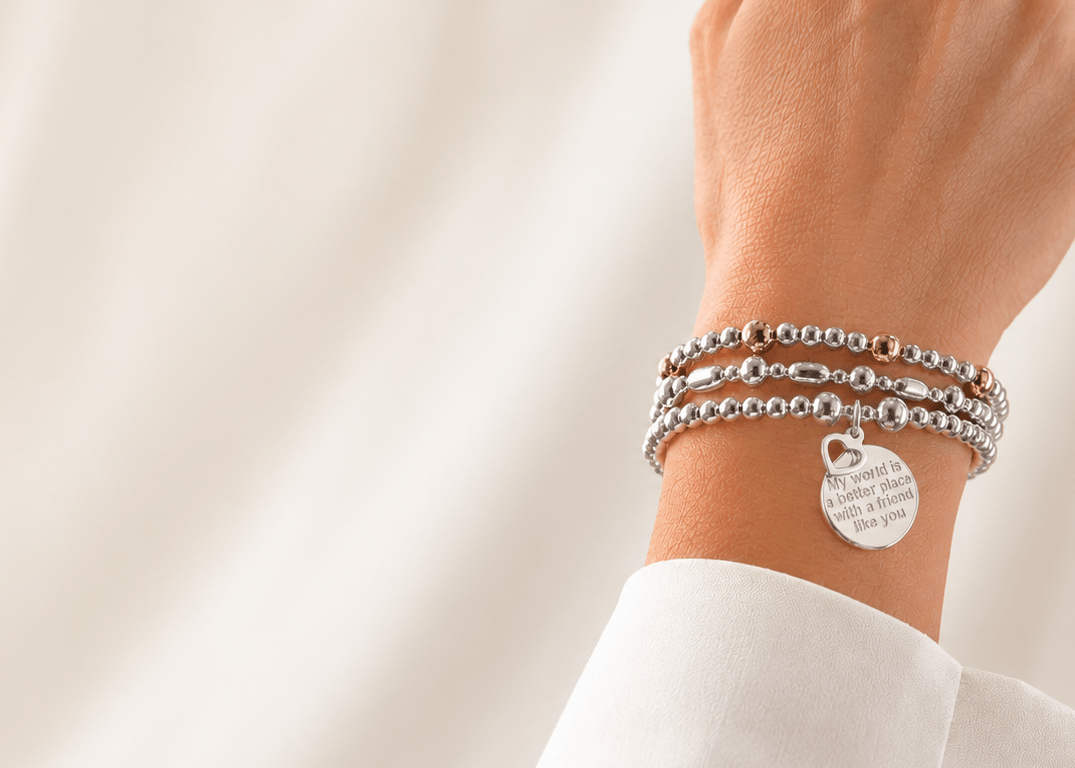 A hand modelling a silver beaded friendship bracelet