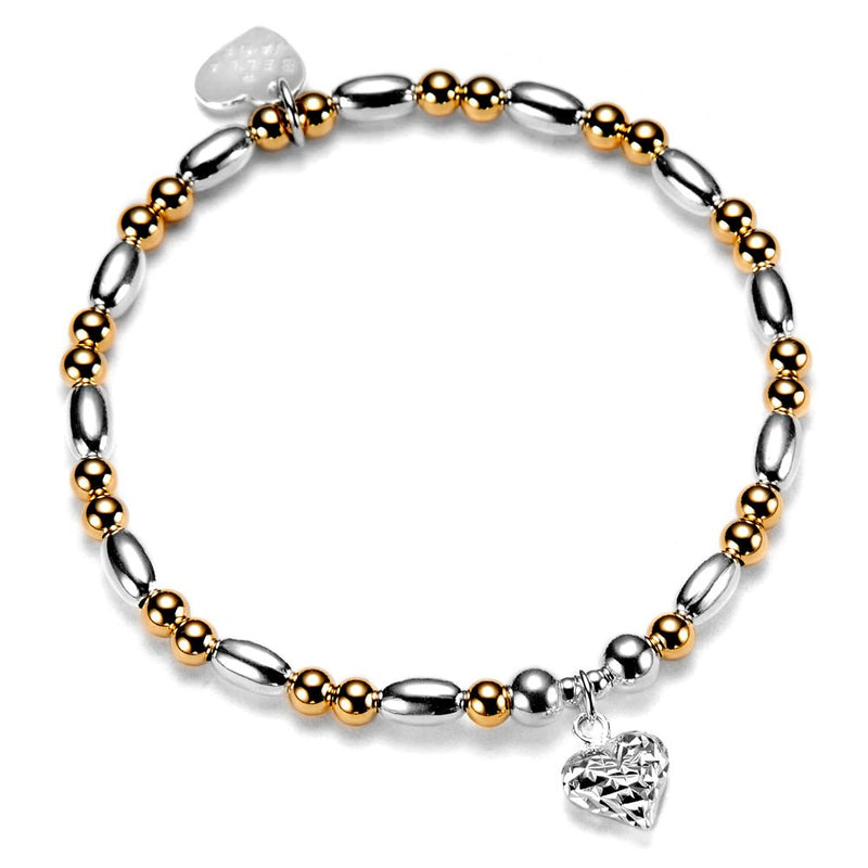 Bracelet with silver and gold beads and a heart-shaped charm on a white background