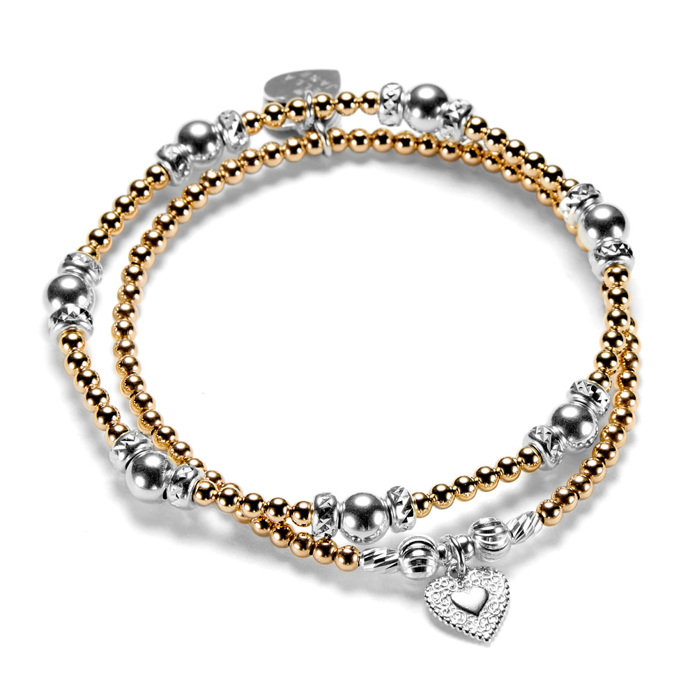 Silver and gold-filled beaded bracelet duo with silver heart charm on a white background