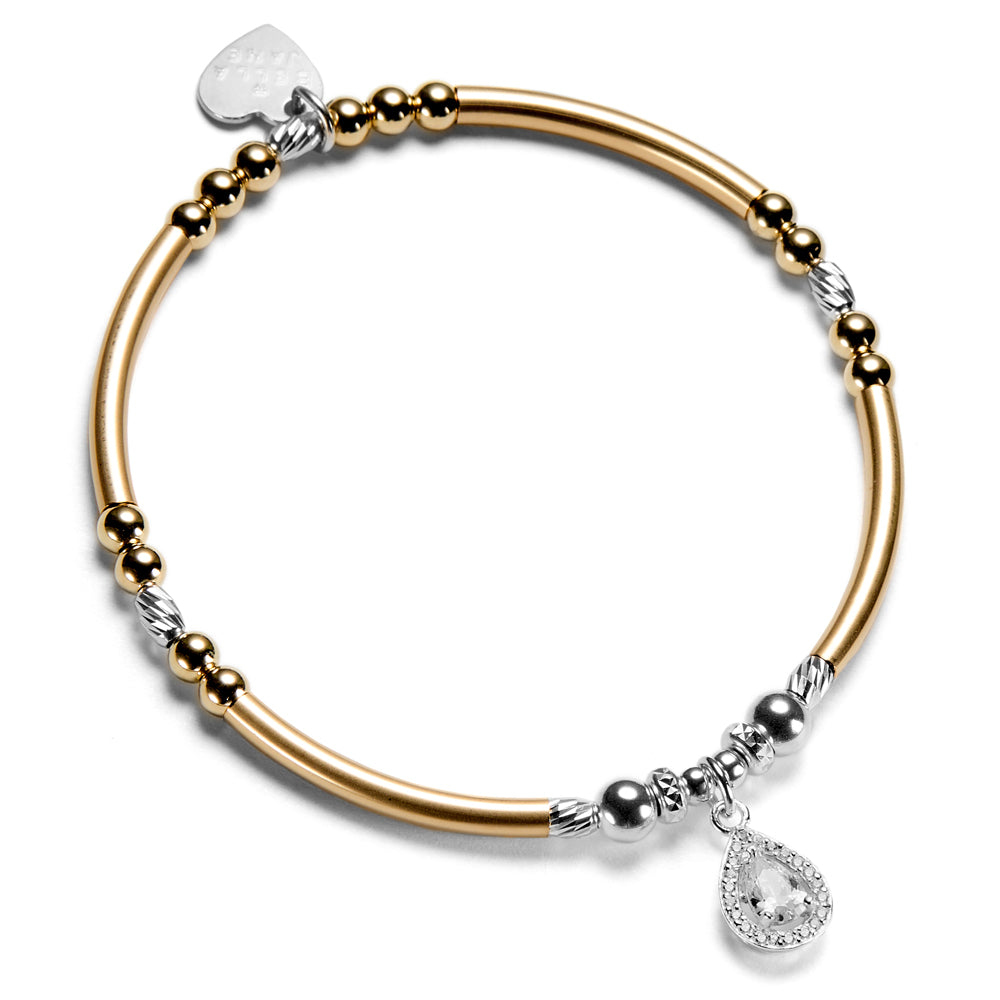 Gold and silver beaded bracelet with a sparkly cubic zirconia shaped charm, on a white background