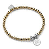 Gold beaded bracelet with a silver charm on a white background