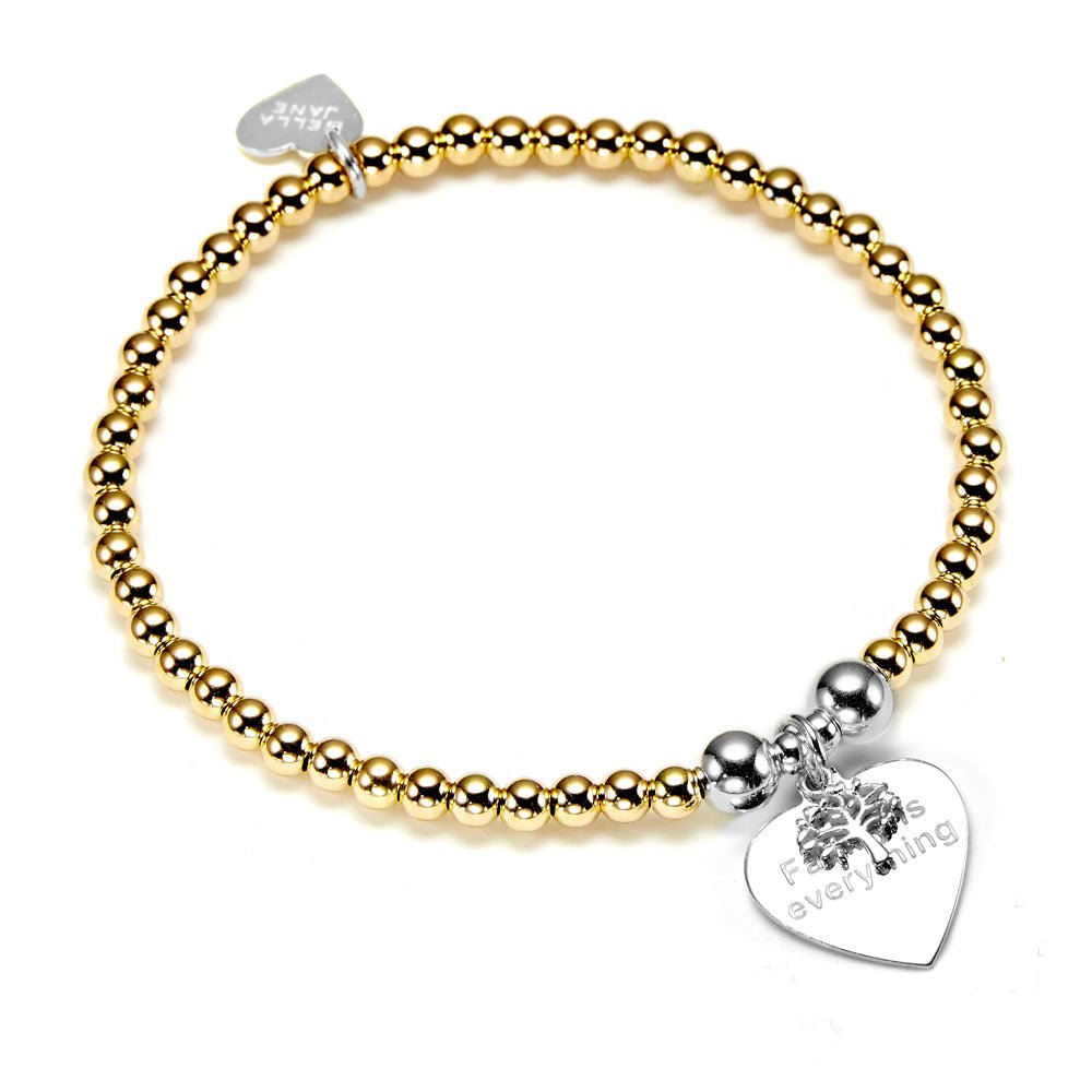 A gold beaded bracelet with a silver heart-shaped tag and family tree on a white background