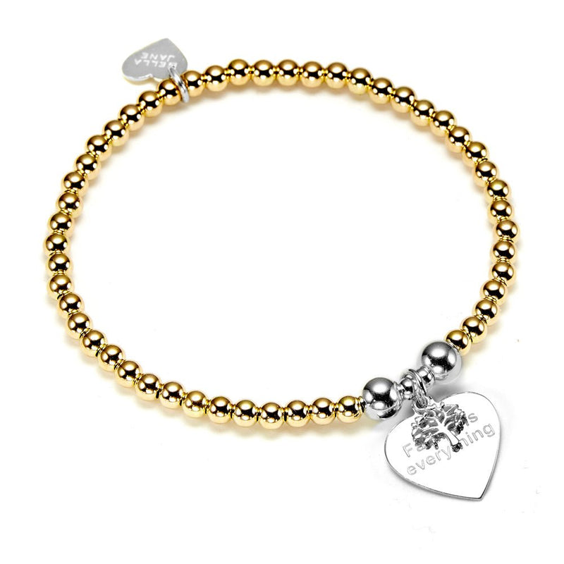 A gold beaded bracelet with a silver heart-shaped tag and family tree on a white background