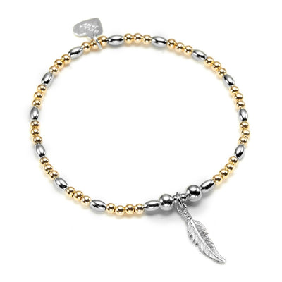 Bracelet with gold and silver beads and a feather charm on a white background