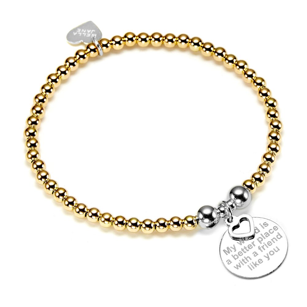 A gold beaded bracelet with a silver charm engraved with a friendship quote pictured on a white background