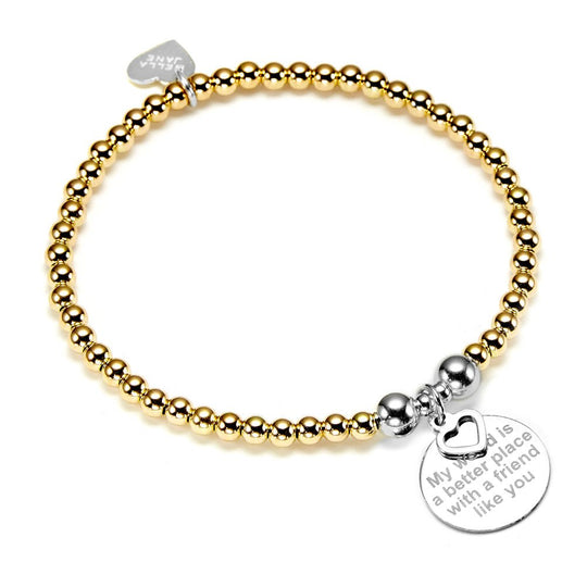 A gold beaded bracelet with a silver charm engraved with a friendship quote pictured on a white background
