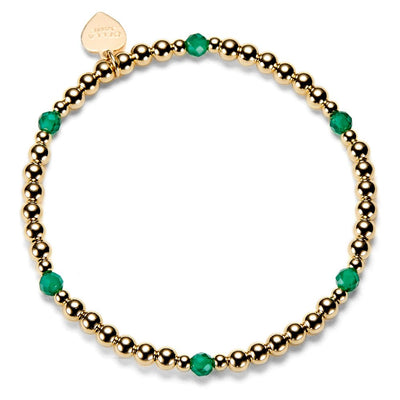 Gold beaded bracelet with green beads on a white background