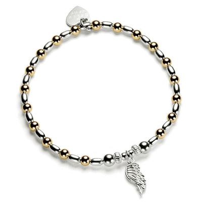Bracelet with gold and silver beads and a wing charm on a white background