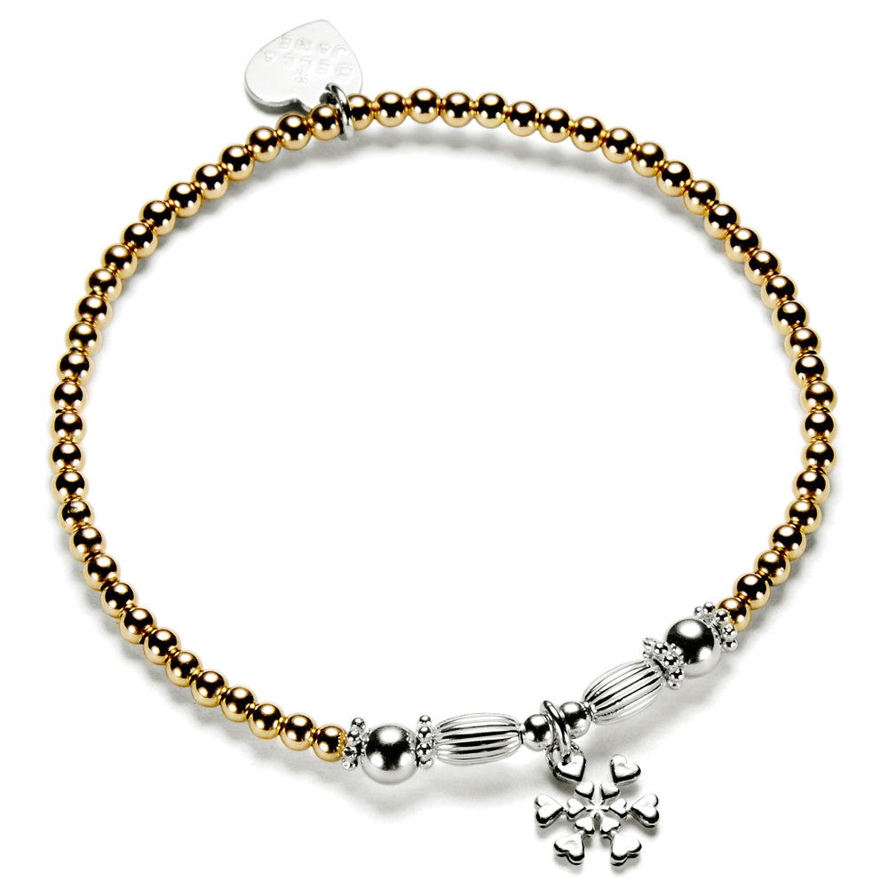 A gold-filled and sterling silver beaded stacking bracelet with oval and round focal beads and a sterling silver snowflake charm.