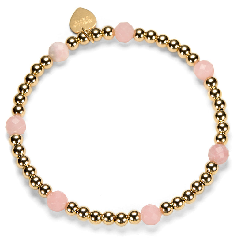 Beaded stacking bracelet with gold-filled and pink opal beads, with Bella Jane branded gold-filled heart tag, on a white background.
