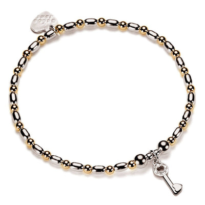 Bracelet with gold-filled and sterling silver beads with a key charm on a white background
