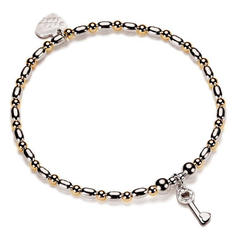 Bracelet with gold-filled and sterling silver beads with a key charm on a white background