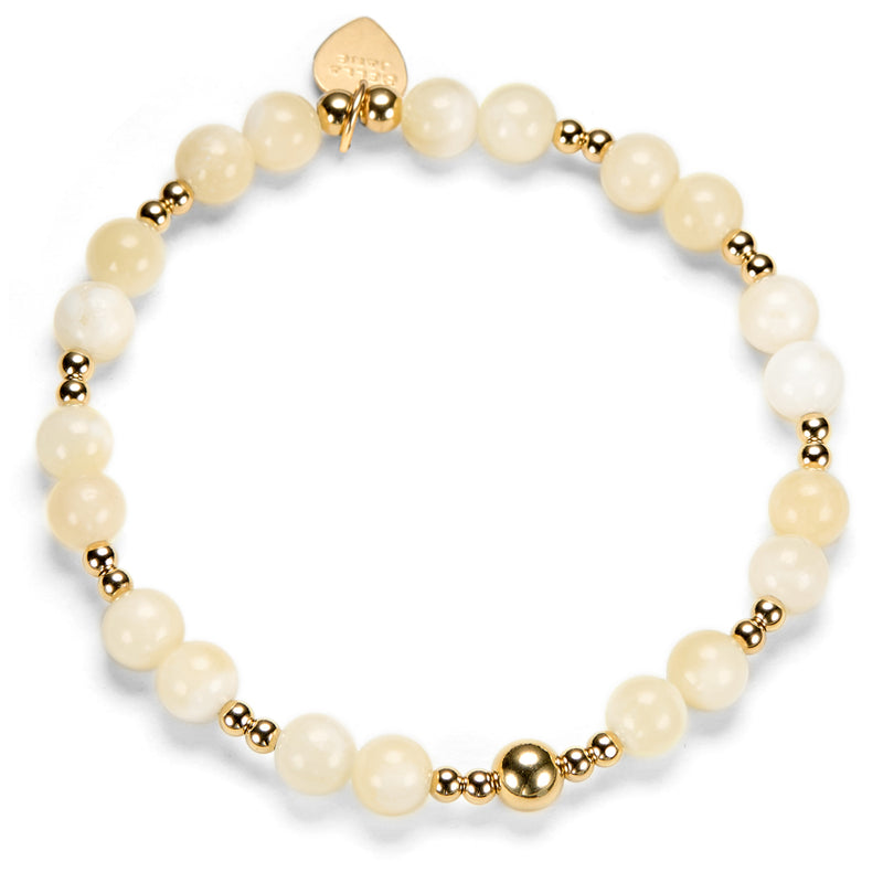 Bracelet with pale lemon-colored beads and gold accents on a white background