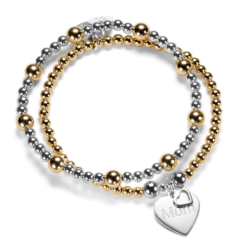 Two gold and silver beaded stacking bracelets with a heart-shaped 'Mum' charm on a white background