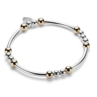 Sterling silver and gold-filled beaded bracelet with noodle shaped and round beads on a white background