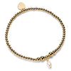 Gold beaded bracelet with a pearl charm on a white background