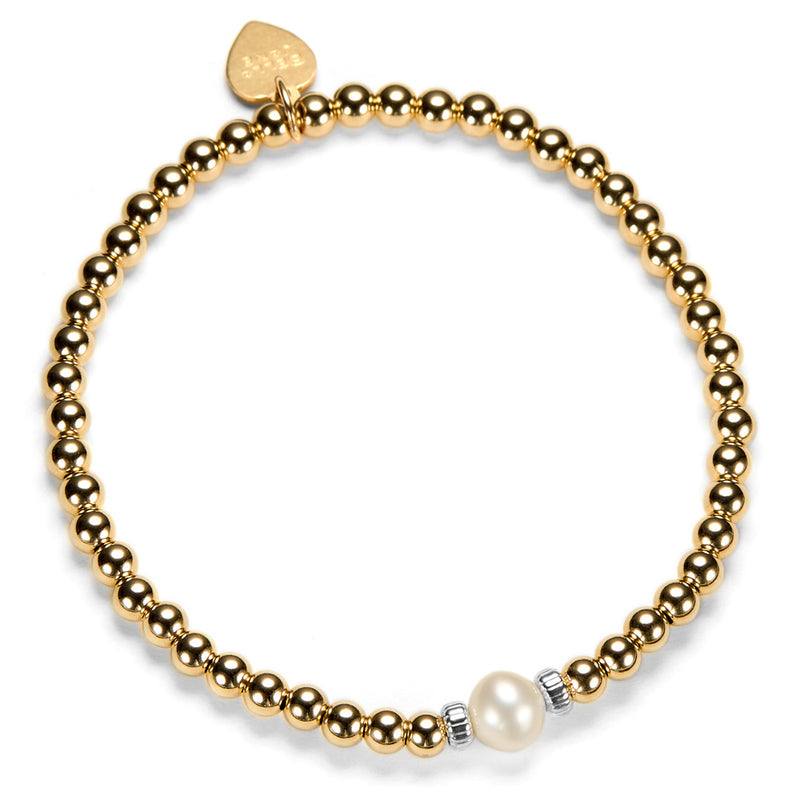 Gold beaded bracelet with a pearl focal bead on a white background