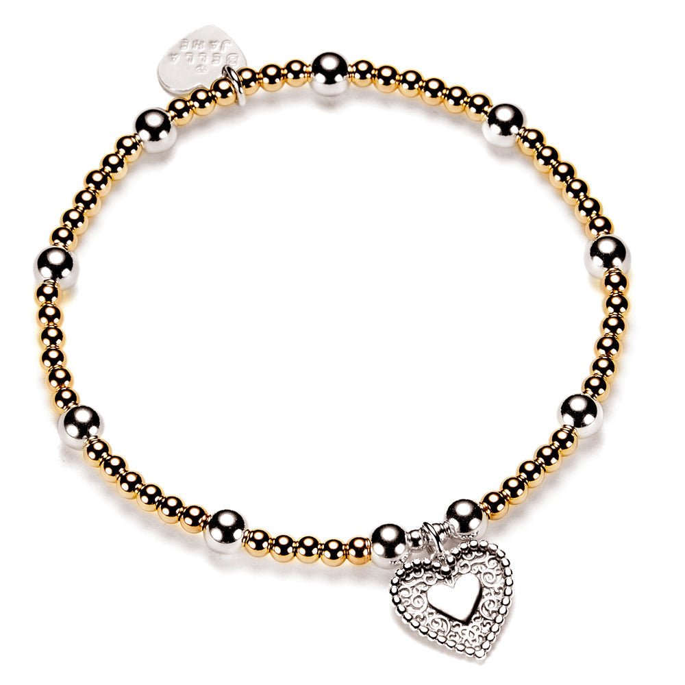 Bracelet with gold and silver beads and a heart-shaped charm on a white background