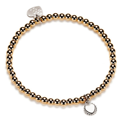 Gold beaded bracelet with heart-shaped disc charm on a white background