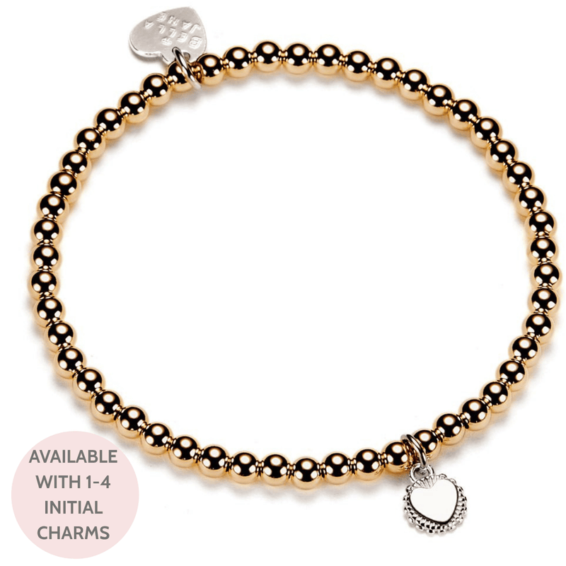 Gold beaded bracelet with heart-shaped disc charm on a white background