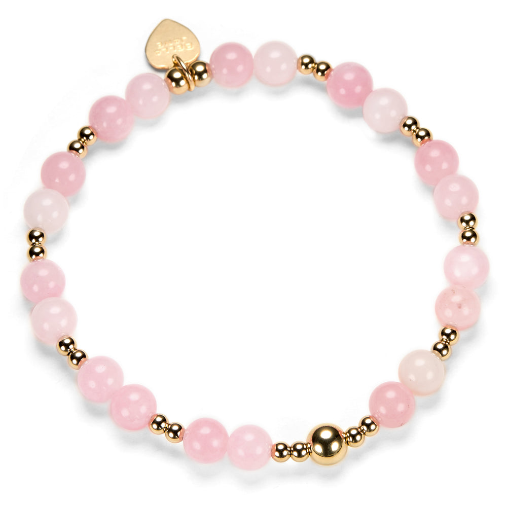 Pink beaded bracelet with gold accents on a white background