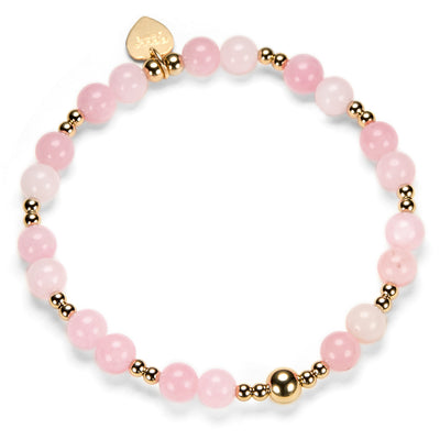 Pink beaded bracelet with gold accents on a white background