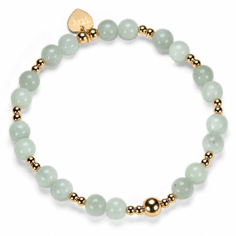 Bracelet with light green beads and gold accents on a white background