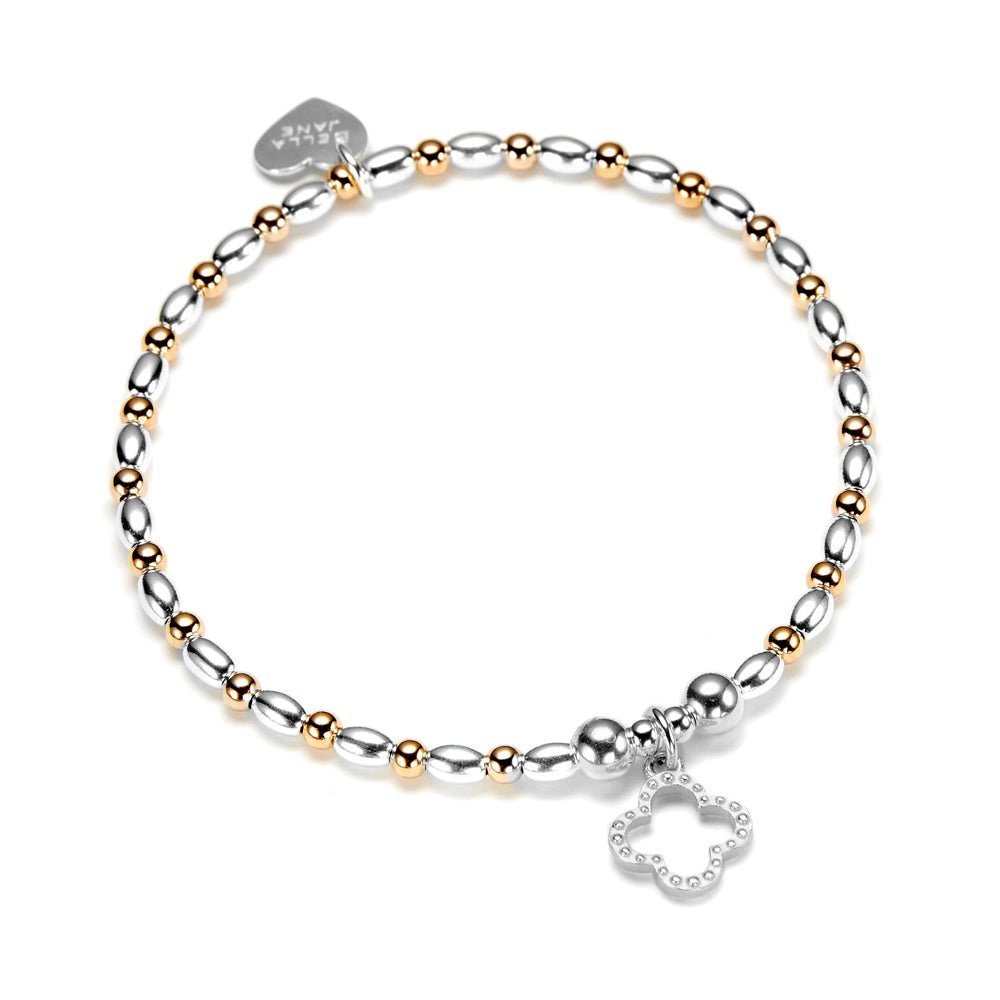 Gold and silver beaded bracelet with a clover charm on a white background.