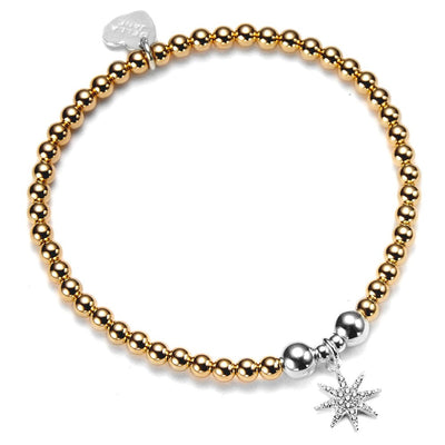 Gold beaded bracelet with a sparkly, silver starburst charm on a white background