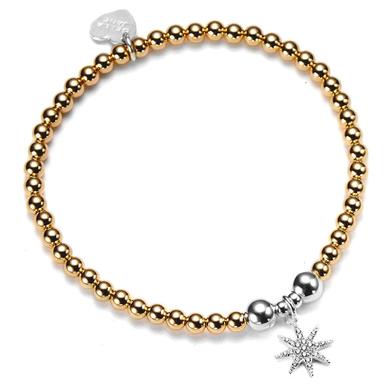 Gold beaded bracelet with a sparkly, silver starburst charm on a white background