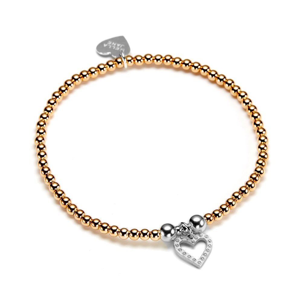 Gold beaded bracelet with studded silver heart charm on a white background