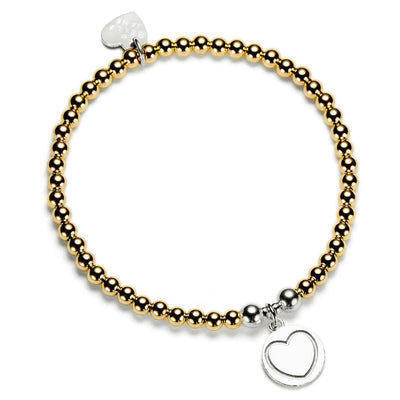 Bracelet with gold and silver beads and  round silver disc charm with a heart on it, on a white background