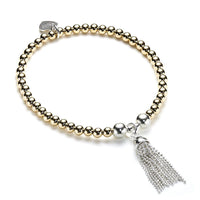 Beaded gold-filled and sterling silver stacking bracelet with silver tassel charm on a white background
