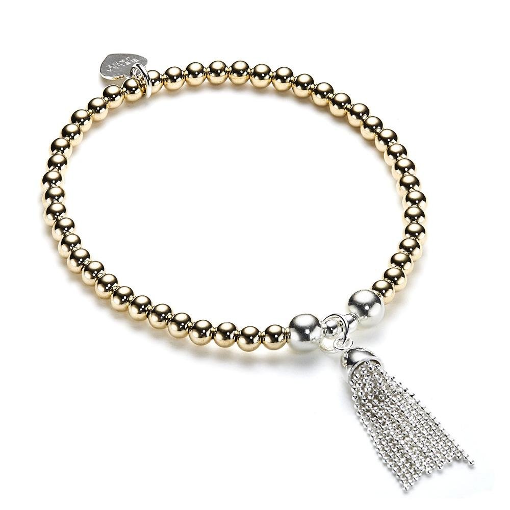 Beaded gold-filled and sterling silver stacking bracelet with silver tassel charm on a white background