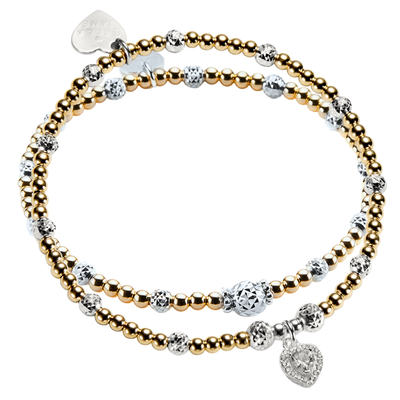 Two gold and silver mixed metal beaded stacking bracelets, one with a sparkly heart-shaped charm on a white background.