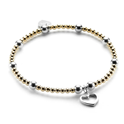 Gold-fiilled and sterling silver beaded bracelet featuring a silver open heart charm on a white background