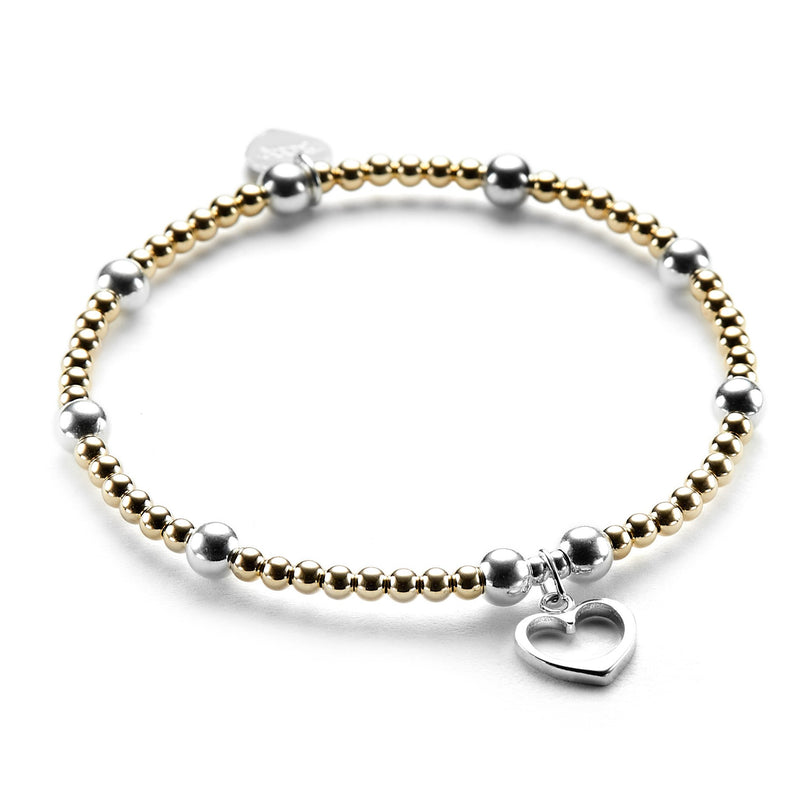 Gold-fiilled and sterling silver beaded bracelet featuring a silver open heart charm on a white background