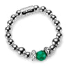 A sterling silver beaded ring with a green gemstone on a white background