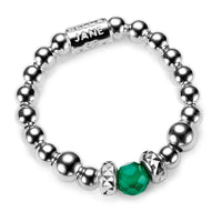 A sterling silver beaded ring with a green gemstone on a white background