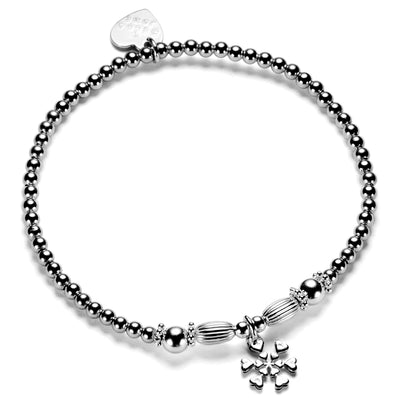 A sterling silver beaded stacking bracelet with oval and round focal beads and a sterling silver snowflake charm.