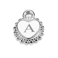 A close up of a small heart disc with engraved initial 'A' on a white background.