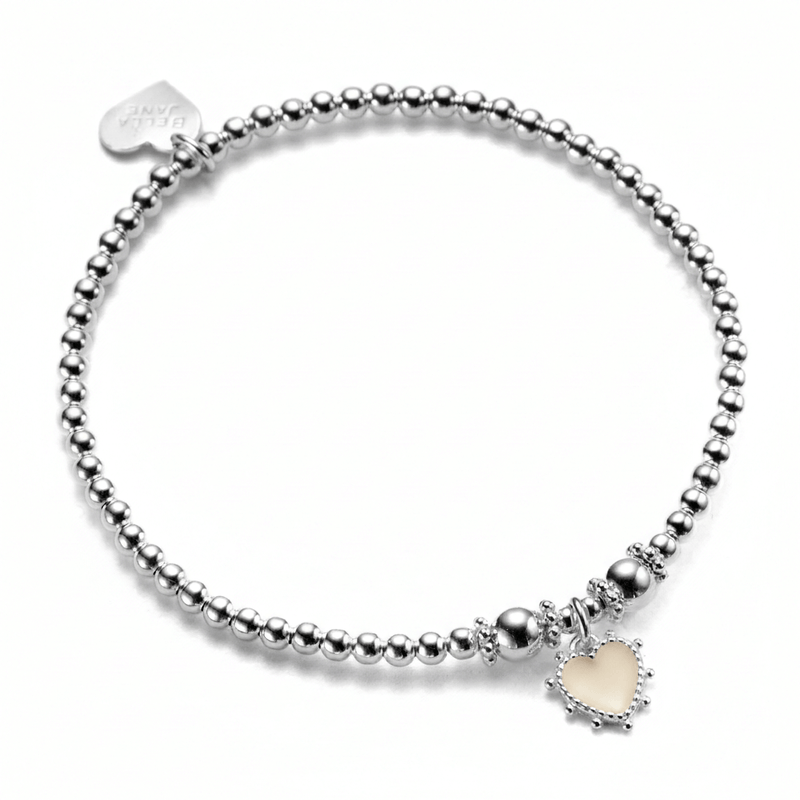 A sterling silver beaded bracelet, featuring a sterling silver and ivory coloured enamel heart charm, with little silver bobbles around the edge of the heart. The photo is against a white background.