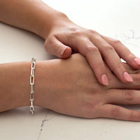Close up of a wrist wearing the bestselling Bella Jane sterling silver Links chain bracelet against a white marble background