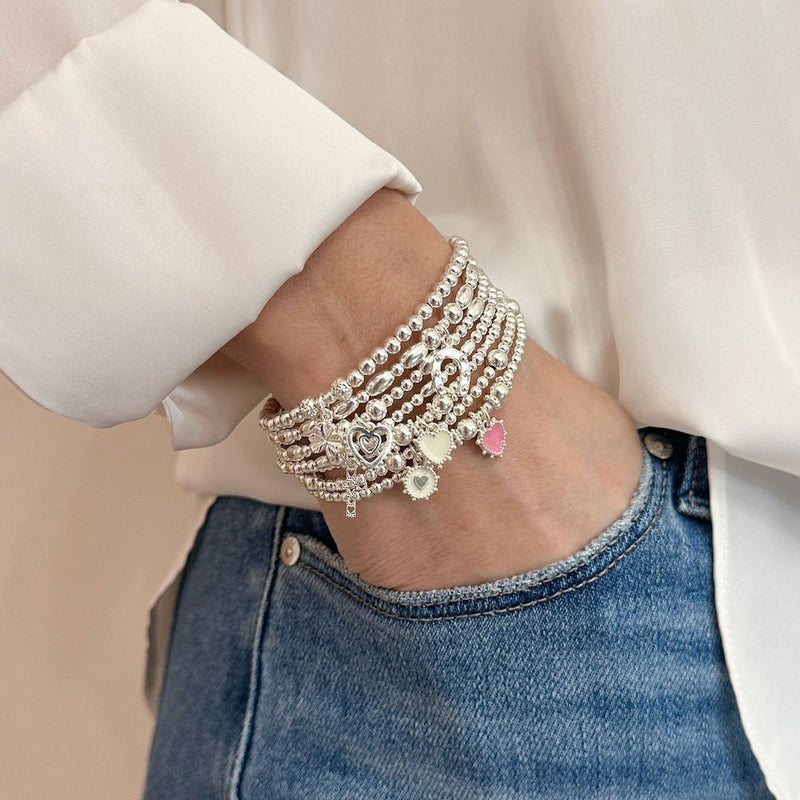 A wrist with sterling silver beaded stacking bracelets