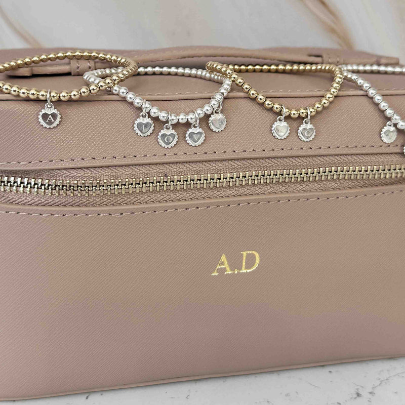 4 beaded bracelets with initial disc charms on a personalised jewellery box