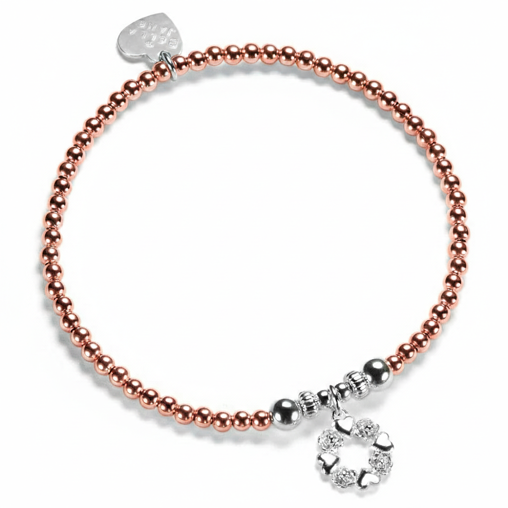 A Bella Jane rose gold-filled and sterling silver beaded bracelet on a white background, featuring a silver wreath-shaped charm with alternate little hearts and roses